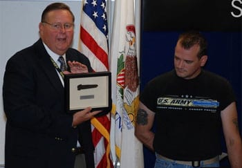 Sheriff Keith Nygren presents the charred knife, framed, to James Halterman. Halterman used the knife, a Gerber Covert 154CM, to cut David Kieffer's seatbelt after his vehicle caught fire. With help from Dan Narcisco, Halterman pulled Kieffer to safety.